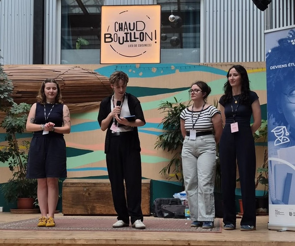 Photo montrant les 4 étudiants du Projet sur la scène du Chaud Bouillon pour faire le discours d'ouverture de l'exposition.